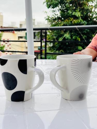 two coffee mugs sitting on top of a table at AHA Luxury Villa - 3BR Retreat in Central Udaipur in Udaipur