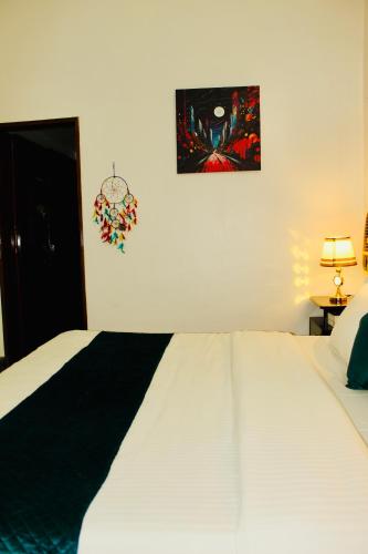 a bedroom with a white bed and a picture on the wall at AHA Luxury Villa - 3BR Retreat in Central Udaipur in Udaipur