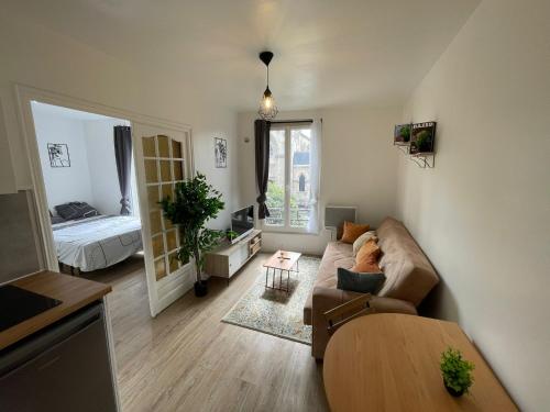a living room with a couch and a bed at Appartement 3 pers, métro direct in Aubervilliers