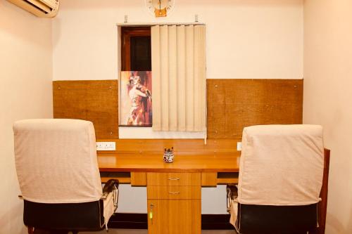 a wooden desk with two chairs in a room at AHA Luxury Villa - 3BR Retreat in Central Udaipur in Udaipur