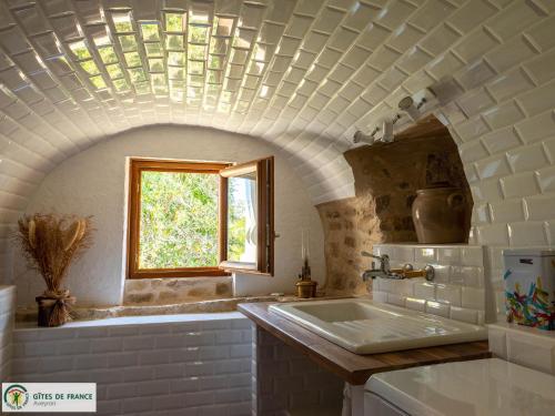 un bagno con lavandino e finestra di Le Pigeonnier du Mas de Salles a Lugan