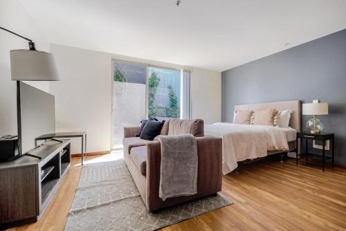 a bedroom with a bed and a couch and a tv at Blueground Brighton balcony nr Seward Park SEA-874 in Seattle