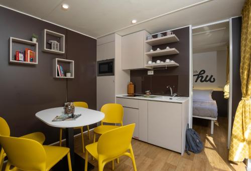 a kitchen and dining room with a table and yellow chairs at hu Firenze Certosa camping in town in Impruneta