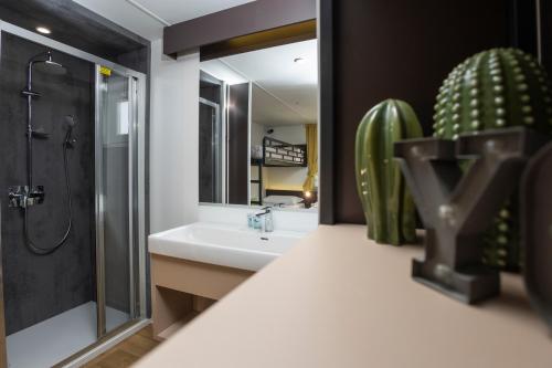 a bathroom with a sink and a shower and a mirror at hu Firenze Certosa camping in town in Impruneta
