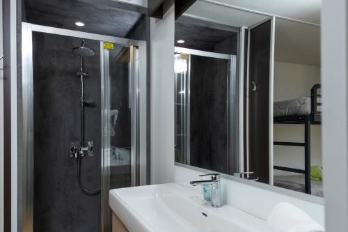 a bathroom with a sink and a shower with a mirror at hu Firenze Certosa camping in town in Impruneta
