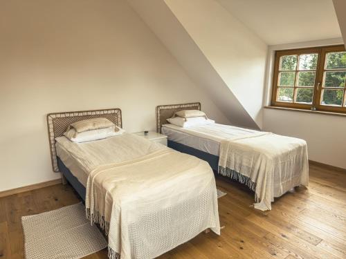 two beds in a room with two windows at Dom w Nowym Sztynorcie in Sztynort