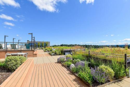 a garden with benches and flowers on a boardwalk at Blueground Brighton balcony nr Seward Park SEA-874 in Seattle