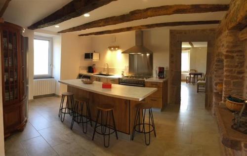 a kitchen with an island with bar stools at Le Mas de Jacquet in Saint-Izaire