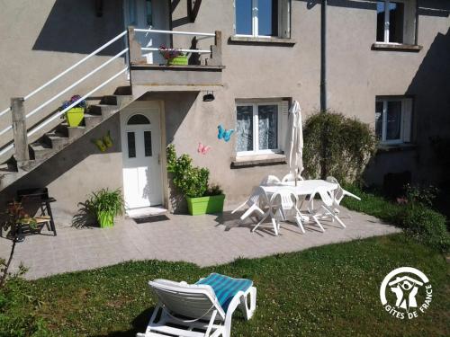 a patio with a table and chairs in front of a house at Gîte entre les Lacs in Curan