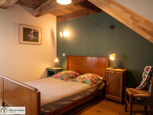 a bedroom with a bed and two lamps on tables at Le Grand Gîte in Cassagnes-Bégonhès