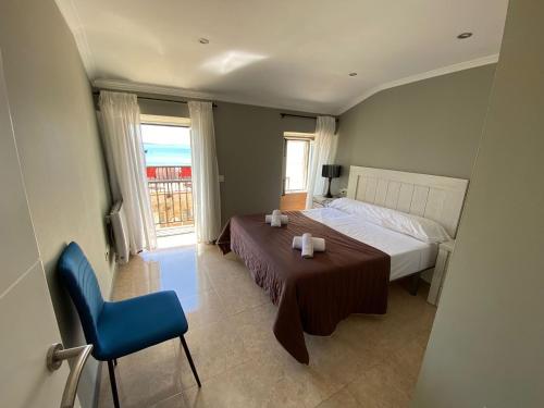 a bedroom with a bed and a blue chair at Casa O Curruncho 3000 in Vilagarcia de Arousa