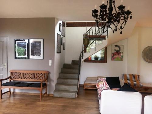 a living room with a staircase and a couch at L'ancienne Grange in Clairvaux-dʼAveyron