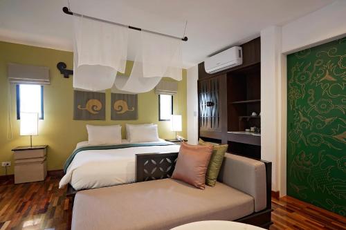 a bedroom with a bed and a couch in it at Praseban Resort in Pran Buri