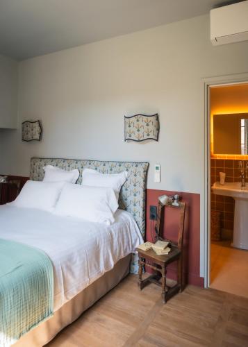 a bedroom with a bed and a table and a mirror at Le Domaine de Richebourg - Pierres d'Histoire in Richebourg