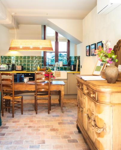 a kitchen and dining room with a table and chairs at Le Domaine de Richebourg - Pierres d'Histoire in Richebourg