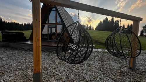 a swing set with two baskets on a pole at La Știubei Cabin in Mărişel