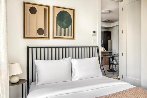 a bedroom with a bed with white pillows and framed pictures at Blueground Boerum Hill rooftop nr Brooklyn Bridge NYC-1880 in Brooklyn