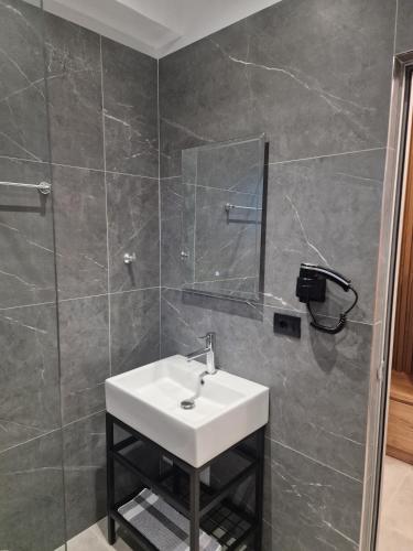 a bathroom with a sink and a mirror at Apelistra Rooms in Himare