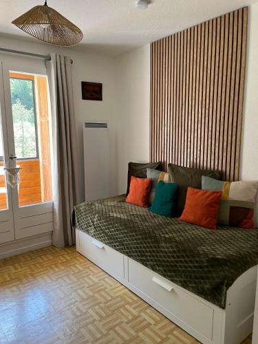a bedroom with a bed with colorful pillows on it at Le flocon in Allos