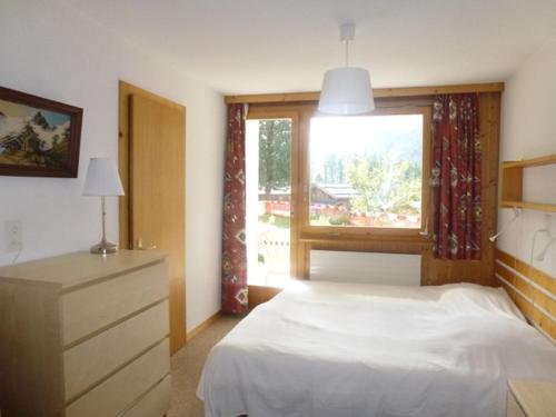 a bedroom with a white bed and a window at Erables 303-304 in Zinal