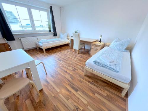 a small room with two beds and a desk at V Apartment 4 Personen - Monteurzimmer - Ferienwohnung - Dingolfing in Dingolfing