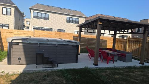 a gazebo with two chairs and a table in a backyard at PARADISE VILLa Bowmanville in Bowmanville
