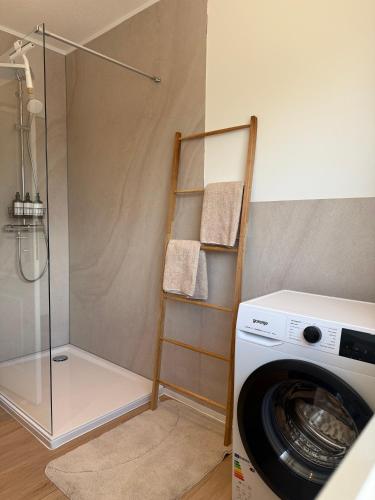 a laundry room with a washing machine and a shower at Ildiz Ferienwohnungen in Wiefelstede
