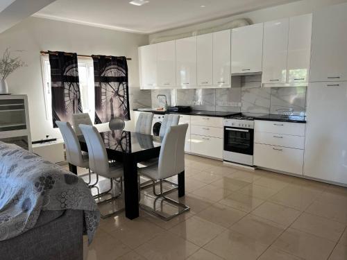 a kitchen with a dining room table and white cabinets at ANDRIA'S luxury family studio near Casino limassol in Limassol