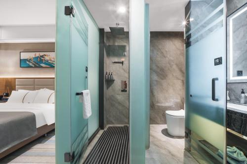 a bedroom with a bed and a bathroom with a shower at Lan Ou International Hotel Atushi in Artux