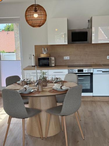 a kitchen with a wooden table and chairs at Ildiz Ferienwohnungen in Wiefelstede
