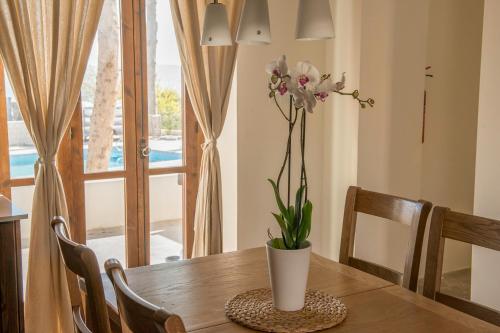 a table with a vase with flowers on it at Ktima 1937 Kannides in Droushia