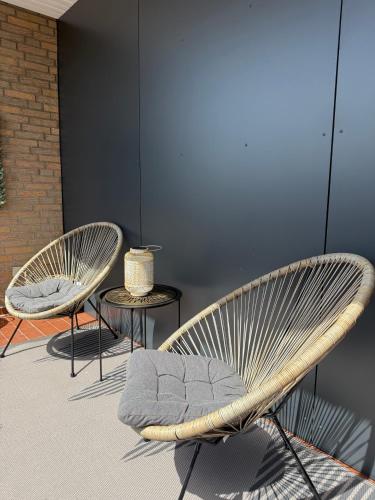 a couple of chairs sitting next to a wall at Ildiz Ferienwohnungen in Wiefelstede