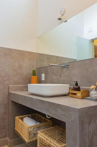 a bathroom counter with a sink and a mirror at Pariri Suites in Trancoso