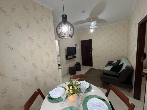 a living room with a table and a couch at Canto do Forte - 1dorm - ate 6 Hospedes, recém reformado próximo a Av Gastronômica de melhores bares e restaurantes com musica ao vivo in Praia Grande