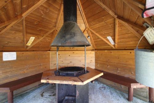 an oven in a wooden cabin with a roof at Huge Cozy Bell Tent with Tv and Heating in Llanfairpwllgwyngyll