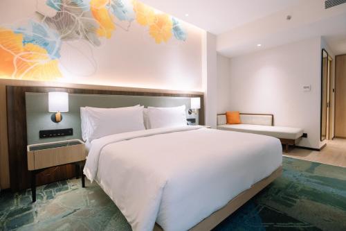 a bedroom with a large white bed and a couch at Holiday Inn Lampung Bukit Randu by IHG in Bandar Lampung
