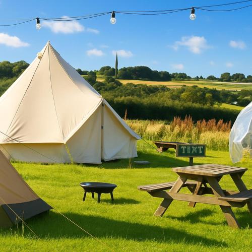 a tent and a picnic table in a field at Huge Cozy Bell Tent with Tv and Heating in Llanfairpwllgwyngyll