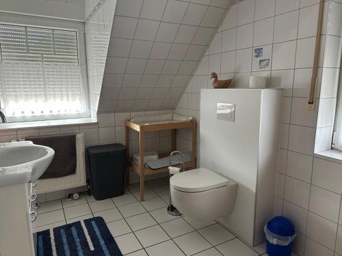 a small bathroom with a toilet and a sink at Möwennest in Krummhörn