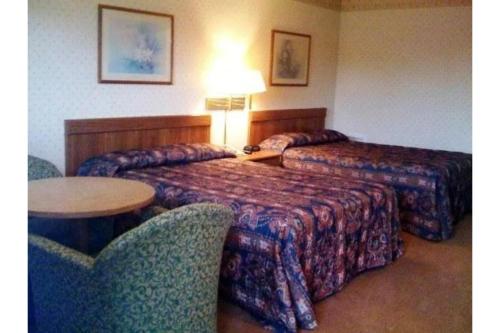 a hotel room with two beds and a table and chairs at Hotel O Relax Inn Lewisburg near I-64 in Lewisburg