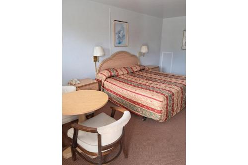 a hotel room with a bed and a table at Hotel O Relax Inn Lewisburg near I-64 in Lewisburg