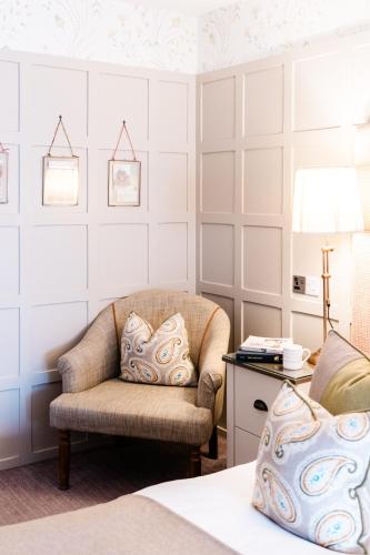 a bedroom with a chair and a table with a lamp at Rothay Manor Hotel in Ambleside