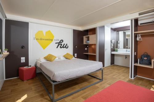a bedroom with a bed with a sign on the wall at hu Firenze Certosa camping in town in Impruneta