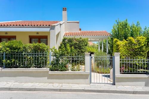 a fence in front of a house at Villa Olia in Nea Roda
