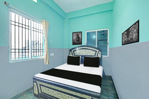 a blue bedroom with a bed and two windows at Hotel O Raunak Food Plaza Family Restaurant & Rooms in Fatwa