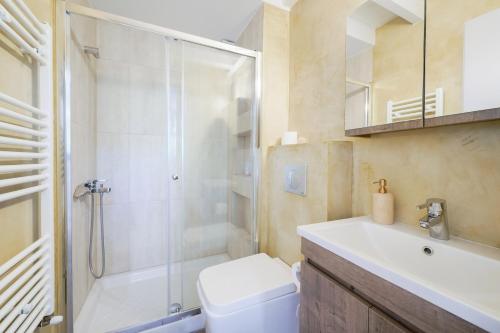 a bathroom with a shower and a toilet and a sink at Villa Olia in Nea Roda