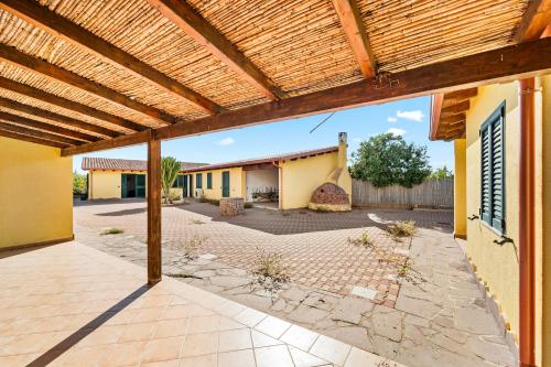 an outdoor patio with a wooden pergola at Residence Sulcis 2 in Masainas