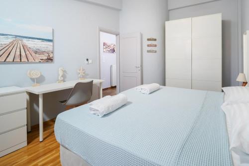 a white bedroom with a desk and a bed at Villa Olia in Nea Roda