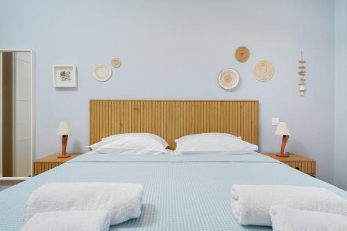 a bedroom with a blue bed with two white pillows at Villa Olia in Nea Roda