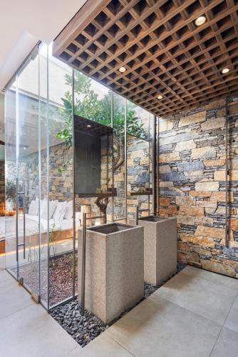 a bathroom with a stone wall and a sink at Voyage Torba Hotel in Torba
