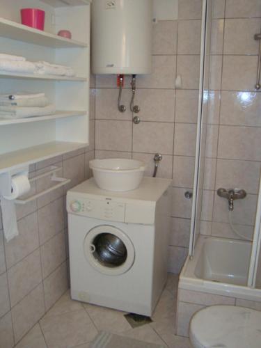 a bathroom with a washing machine and a shower at Blue Holidays Apartment in Šibenik